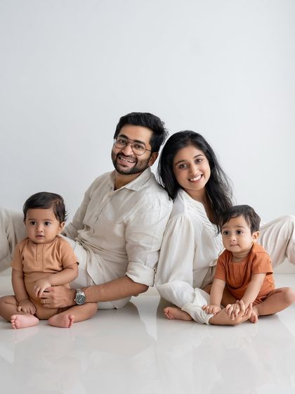 A lovely family portrait with two young children, all dressed in coordinating neutral outfits.