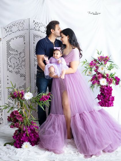 A classic family pose with a tender kiss from dad. The beautiful gowns and floral setup make this a truly special portrait.