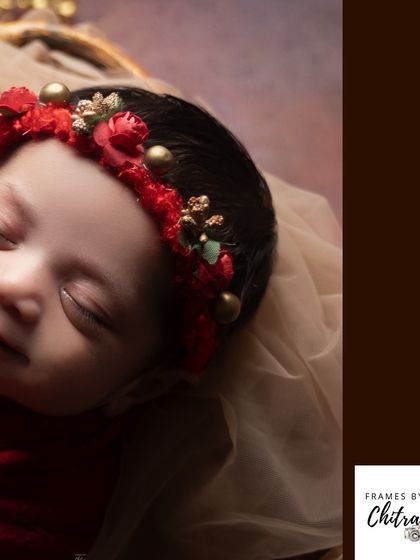 A detailed close-up of a festive red and gold headband on a sleeping baby, perfect for a holiday-themed shoot.