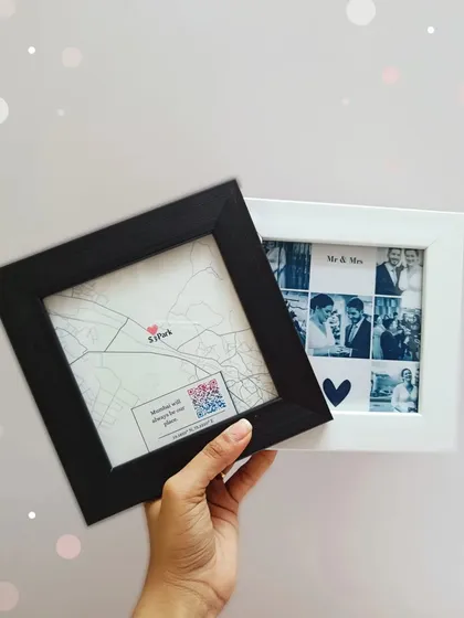 A hand holds the two mini frames, offering a size comparison between the square map frame and the rectangular photo collage frame.