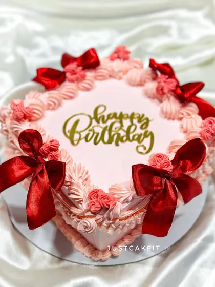 A vintage-style cake with intricate piping and bright red satin bows. This design is perfect for a classic, elegant celebration.