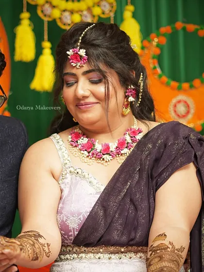 A beautiful Mehendi look featuring a soft purple smokey eye and floral jewellery. The makeup is glamorous enough for photos but still comfortable for the long hours of the ceremony.
