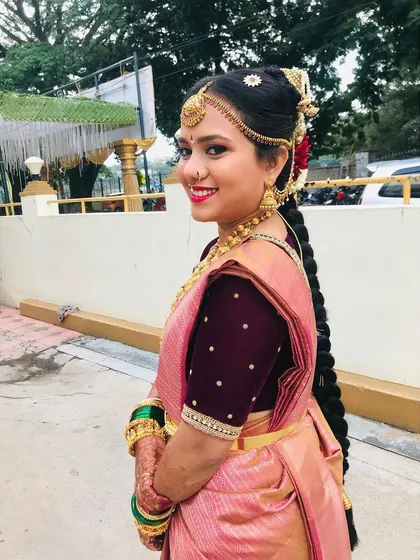 A happy, smiling bride after her Gouri Pooja. The traditional hairstyle and makeup look absolutely beautiful on her.