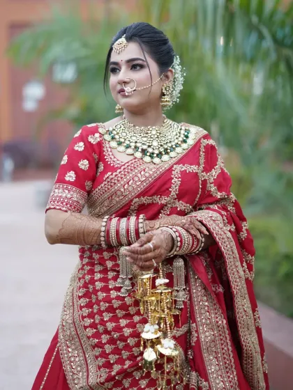 A full portrait of the bride, her soft glam makeup perfectly complementing the heavy embroidery of her lehenga.