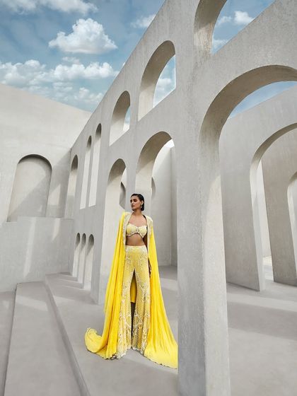 A breathtaking sharara set, fully embroidered and paired with a flowing cape that billows like a prism-cast aura. A dance of radiance and grace.