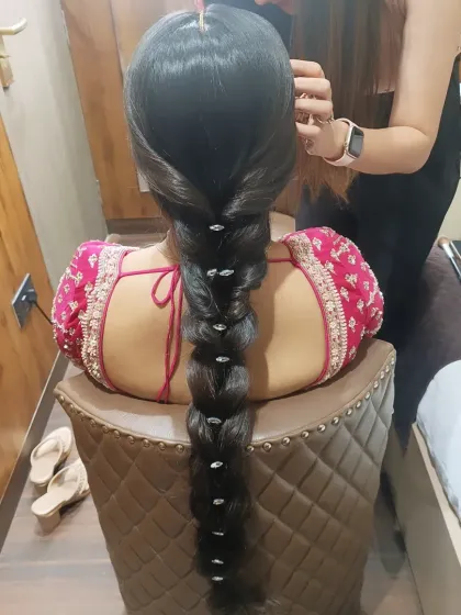 A sleek and traditional long bubble braid, perfect for brides with long hair. This clean, polished look is punctuated with delicate crystal accessories, adding a touch of sparkle that catches the light.
