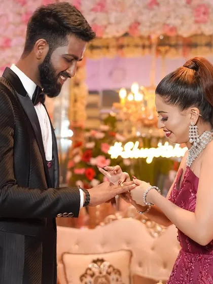 A joyful and candid moment as the couple exchanges rings during their engagement ceremony, with smiles that light up the room.