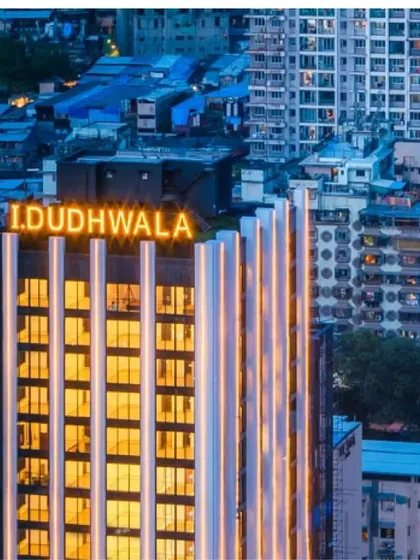 The top of the ID Origins tower, where the calligraphic strokes culminate. The illuminated signage is integrated into the architectural form.