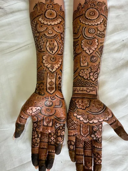An intricate bridal design for an engagement, featuring names and blessings written in Arabic script. The patterns are a beautiful mix of Indian and Arabic styles.