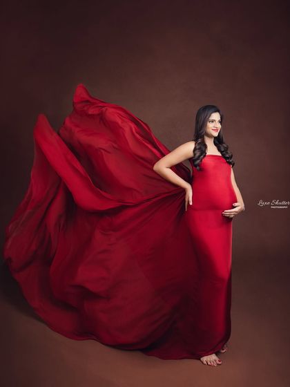 A confident pose showing off the beautiful baby bump. The simple, strapless red gown is a versatile piece from my collection that allows for stunning, dramatic fabric effects.