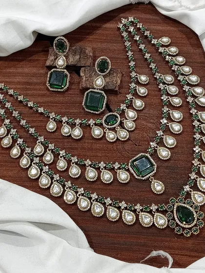 The same three-strand layered necklace design, but with rich emerald-green stones.