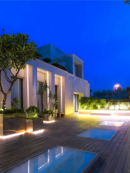Our expertise lies in transforming urban terraces into sophisticated evening retreats. This project showcases strategic lighting design that highlights mature trees in sleek, modern planters and illuminates a spacious wooden deck, creating an atmosphere of serene luxury against the twilight sky.