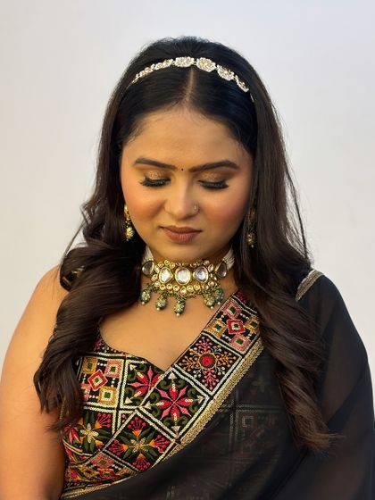 A close-up of a client wearing a black saree with a colorful blouse. The makeup features a brown smokey eye and a nude lip, a classic and versatile party look.