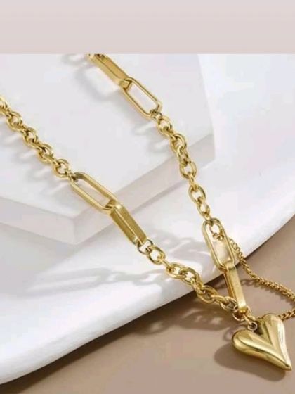 A modern paperclip and classic link chain necklace featuring a puffy heart pendant. This piece combines several popular trends in one design.