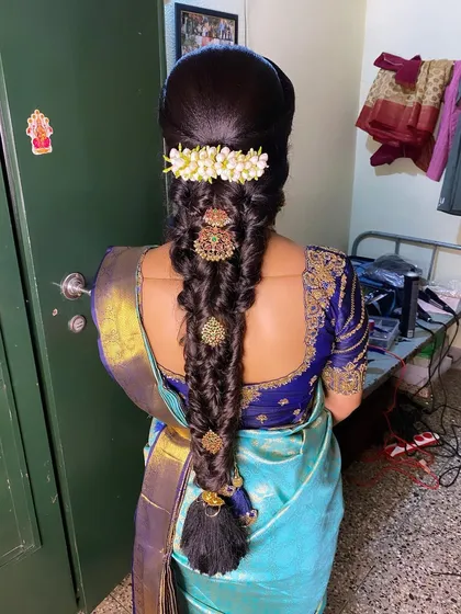 A beautiful and intricate braid style, decorated with spaced-out temple jewellery and a jasmine gajra. This is a unique and modern take on a traditional look.