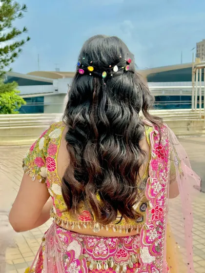The hairstyle for this look was playful and modern, with soft waves and colorful stone accessories to match her vibrant outfit.
