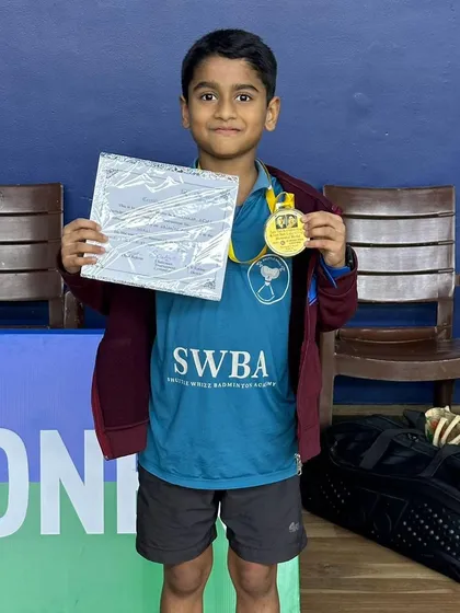 Ajinkya Desai proudly holds his gold medal and certificate for the Under 11 boys singles event. His hard work and perseverance paid off.