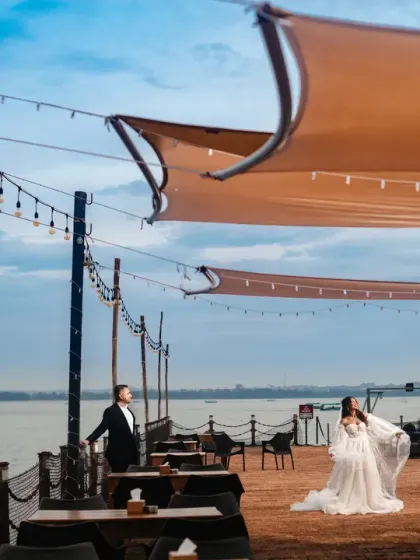 A serene couple portrait on a pier overlooking the water. The soft lighting and calm backdrop create a peaceful, romantic atmosphere, perfect for a relaxed post-wedding or pre-wedding session.