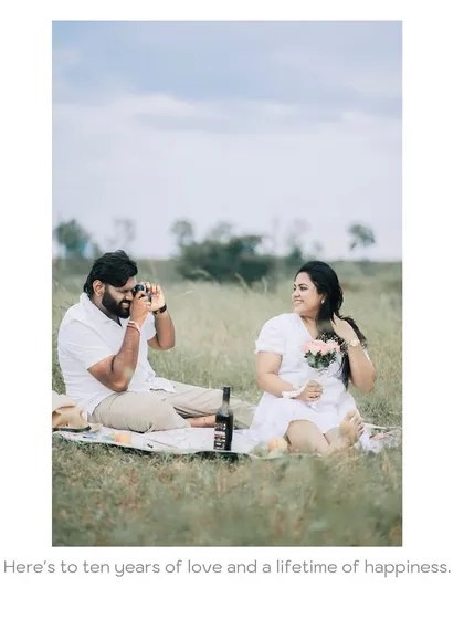 A picnic in a beautiful meadow. The groom-to-be playfully takes a photo of his partner, showing a sweet, candid interaction.