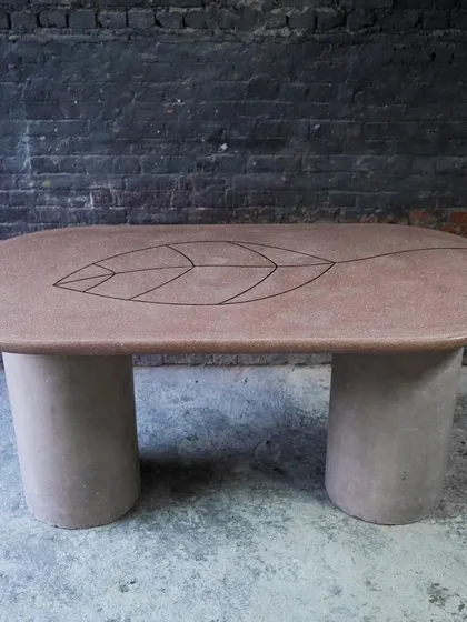 We elevate our surfaces by infusing them with other natural materials. This custom terrazzo dining table features a delicate brass inlay of a leaf, combining the earthy texture of concrete with the refined elegance of metal for a truly one-of-a-kind piece.