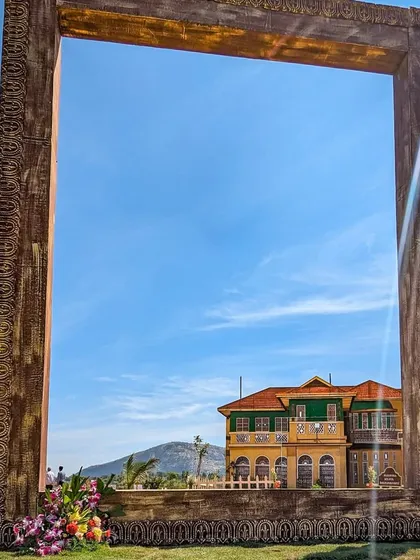 A creative shot of the Unnati clubhouse framed by a giant, ornate picture frame, turning the view into a work of art.