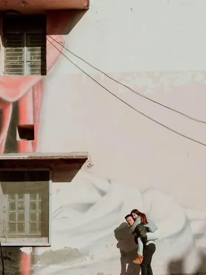 A wide, creative shot of a couple against a large mural in Delhi. We love incorporating local art and urban landscapes to make each destination shoot unique.