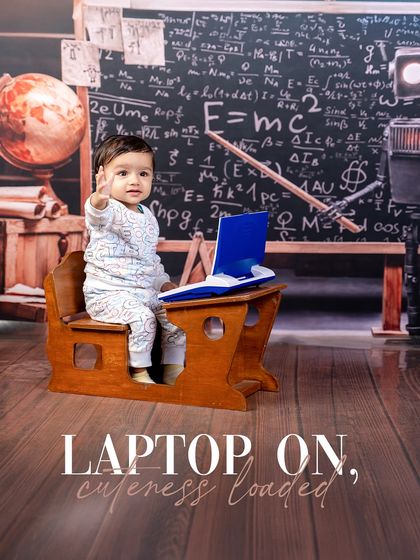 Laptop on, cuteness loaded. This tiny scholar is hard at work on his toy laptop, ready to solve the world's problems from his little desk.