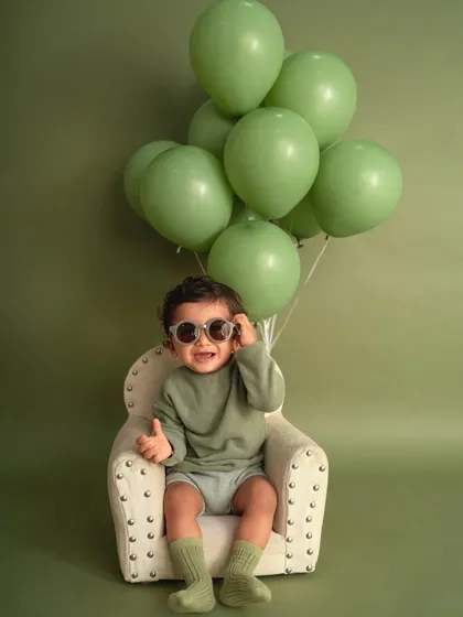 Simple, stylish, and full of personality. This minimalist studio session uses a solid color backdrop and a few fun props, like these cool sunglasses, to put all the focus on your little one's adorable expressions.