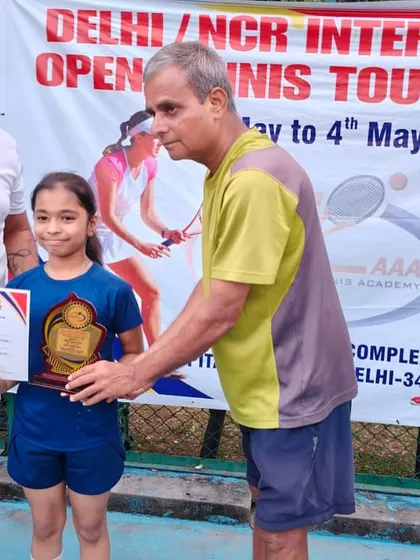 An ILTA champion receiving her trophy at the Delhi/NCR Inter-School Open Tennis Tournament. We train our players for competitive events.