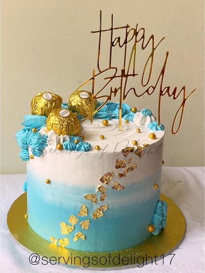 A blue ombre cake topped with Ferrero Rocher chocolates and gold leaf. The combination of blue and gold is always a sophisticated choice.