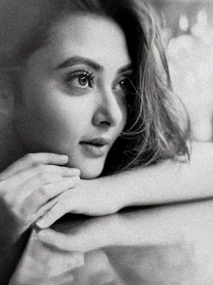 The same portrait of Megha Chowdhury in black and white. The monochrome treatment adds a layer of classic elegance and focuses entirely on her expression and the beautiful lighting.