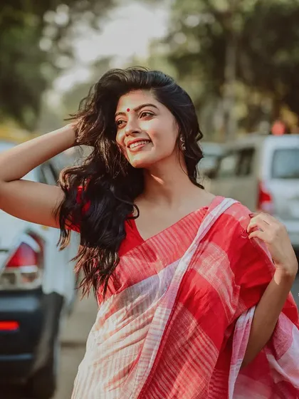 A joyful, candid shot of a model on a busy street. Her bright smile and the motion in her hair create a feeling of freedom and happiness.