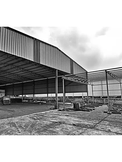 The steel structural framework of the warehouse during the construction phase. This image shows the scale of the industrial building and the engineering that forms its foundation, a key part of our end-to-end architectural services.