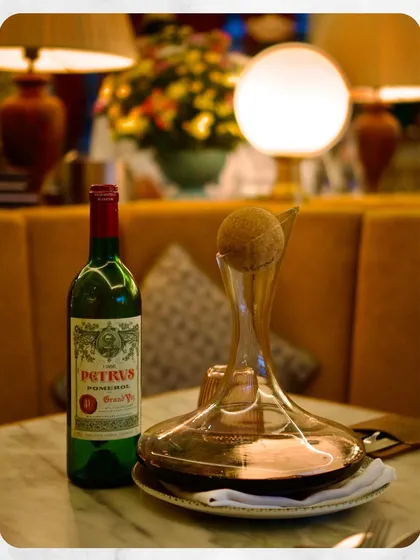 A bottle of 1995 Petrus from Pomerol, ready to be decanted. This represents the pinnacle of our wine collection, showcasing our access to and appreciation for some of the world's most sought-after and iconic fine wines, available for you to experience in our cellar.