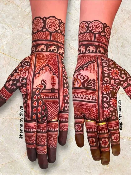 This full-hand design is packed with traditional elements. It features peacocks, swans, and elephants set within ornate arches, surrounded by delicate floral patterns.