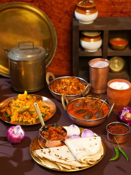 An authentic Maharashtrian thali spread, rich with traditional dishes like Bharli Vangi and Bhakri, served in classic brass and copperware. This image evokes a sense of home-cooked warmth and cultural heritage, inspired by my travels in rural Maharashtra.