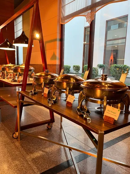 A line of elegant brass and copper chafing dishes, keeping the food warm and adding a touch of class to the buffet.