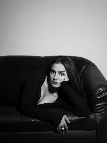 A studio session with a model in a black dress, showcasing a range of poses from pensive to powerful. The lighting is controlled to sculpt the subject and create a sophisticated mood.