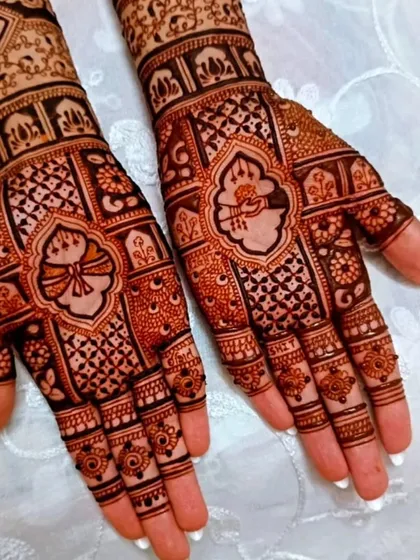 A close-up of intricate palm designs, featuring traditional Indian motifs surrounded by detailed jaal and floral work.