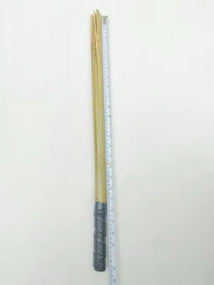 The full length of the clatter stick being measured. Consistency in equipment is important for both the dog and the trainer.