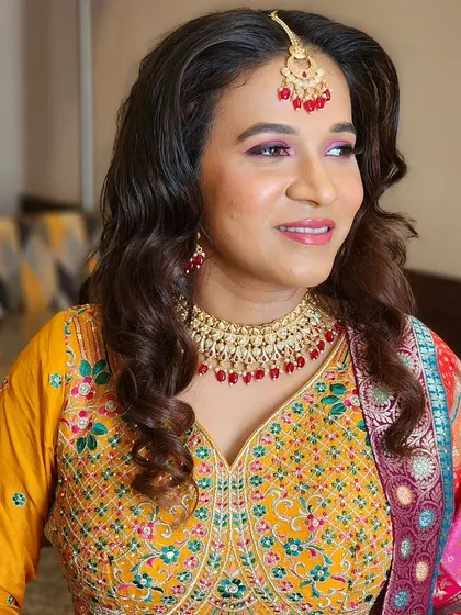 This bride is Haldi-ready with bright, colorful makeup that perfectly matches the festive and joyful spirit of the ceremony.