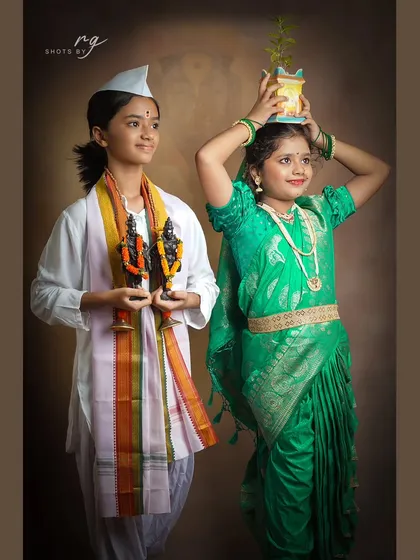 Two girls dressed as Varkaris, one holding the idols of Vithal and Rukmini, and the other with a Tulsi plant, for our Ashadhi Ekadashi shoot.
