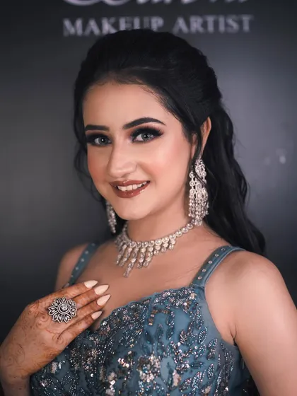 A smiling portrait of the bride. Her makeup is glamorous yet approachable, with a focus on radiant skin and sparkling eyes.