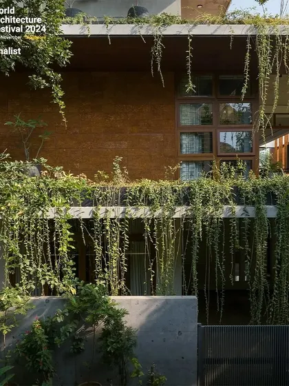 A detailed shot of the building's facade where hanging vines create a natural curtain. This living element provides shade, privacy, and a constantly evolving aesthetic as the plants grow and change with the seasons.