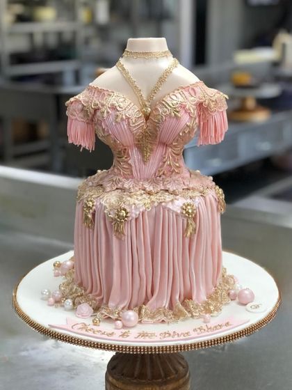 This couture inspired cake was designed to look like an elegant gown. I used fondant draping techniques, edible gold lace details, and delicate sugar pearls to create a truly unique and sophisticated cake for a very special celebration.