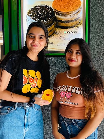 Two friends showing off the cute clay trinkets they made. It's the little things that bring the most joy.