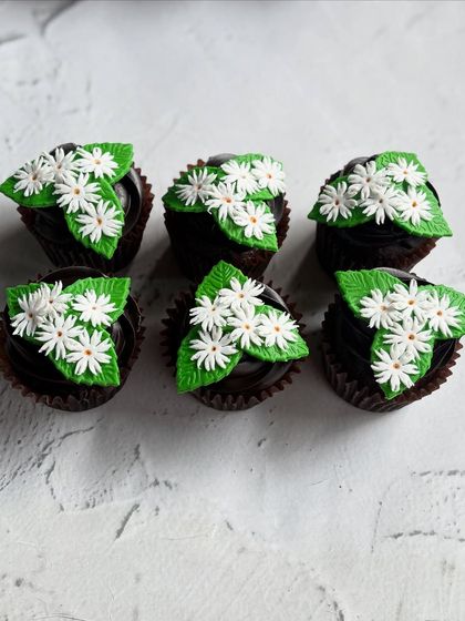 For a more floral and elegant baby shower, I created these chocolate cupcakes topped with a bouquet of handmade fondant daisies. The intricate detail on the flowers adds a beautiful, fresh touch.
