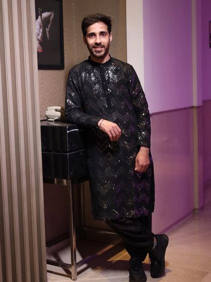 Another shot of the brother of the bride's cocktail outfit. The sequin detailing on the black fabric catches the light beautifully, making it a standout piece for an evening event.