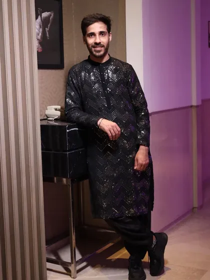 Another shot of the brother of the bride's cocktail outfit. The sequin detailing on the black fabric catches the light beautifully, making it a standout piece for an evening event.