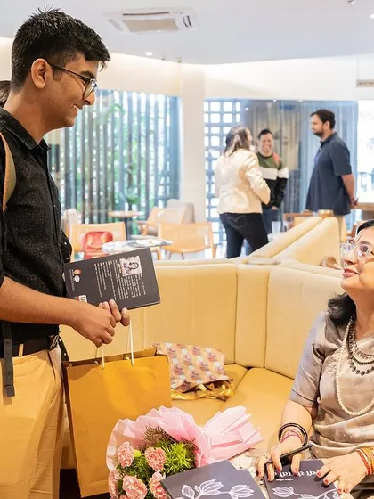 An author and reader share a warm smile and conversation over a signed book.